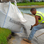 Installing AquaBlok sealing system for a pond bank