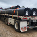 Ferguson Waterworks delivering large rolls of geomembrane liner to a job site