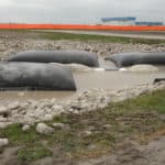 Several dewatering bags on a job site removing silt, sand, and other debris from pumped water