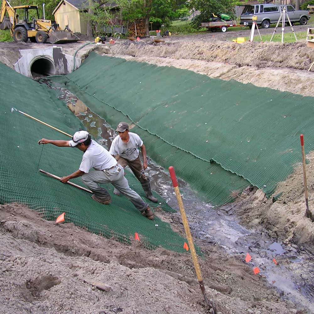 Professionals installing high-performance turf reinforcement mats