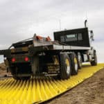 A large construction truck entering a construction zone without damaging the ground.