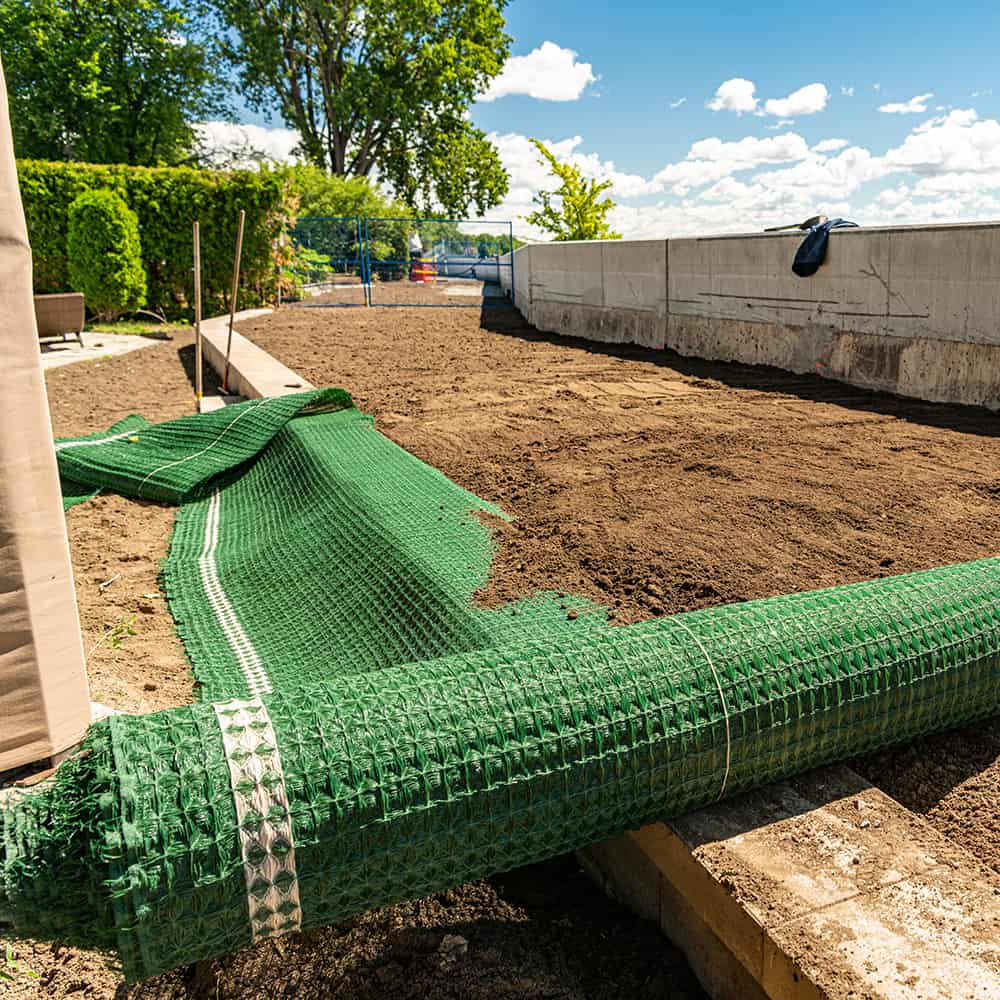 Rolling our a green turf reinforcement mat at a jobsite