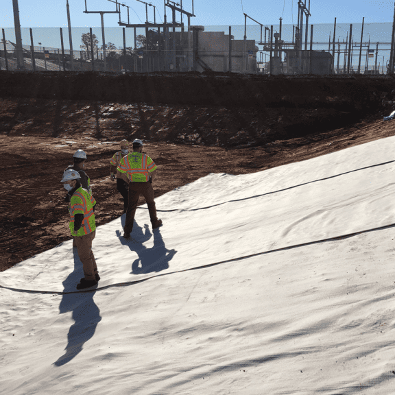 Installing Solmax BENTOLINER NS geosynthetic clay liner on a steep slope.