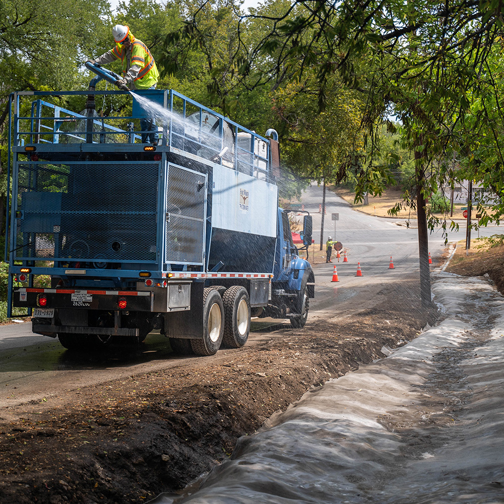 Installing concrete canvas in ditch lining with large water truck