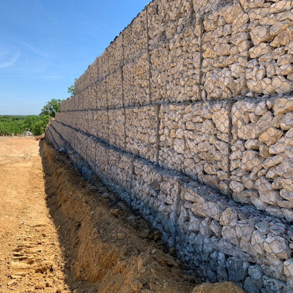 Metal cage for building retaining wall