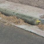 A roadside curb inlet with a sediment catch placed along side the opening.