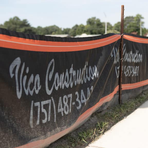 A custom branded silt fence printed with construction company's logo and phone number