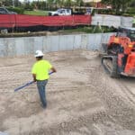 Construction expert operating a skid steer on a construction site to prepare for stormwater filtration system