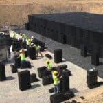 Construction workers on a jobsite assembling R-Tank, a modular underground storage system for stormwater