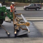 Installing glass fiber paving grid to mitigrate cracks increase pavement longevity