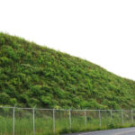 Large, vegetated reinforced soil slope using geosynthetics for stabilization