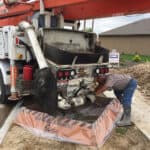 Large cement truck and construction worker over a containment berm