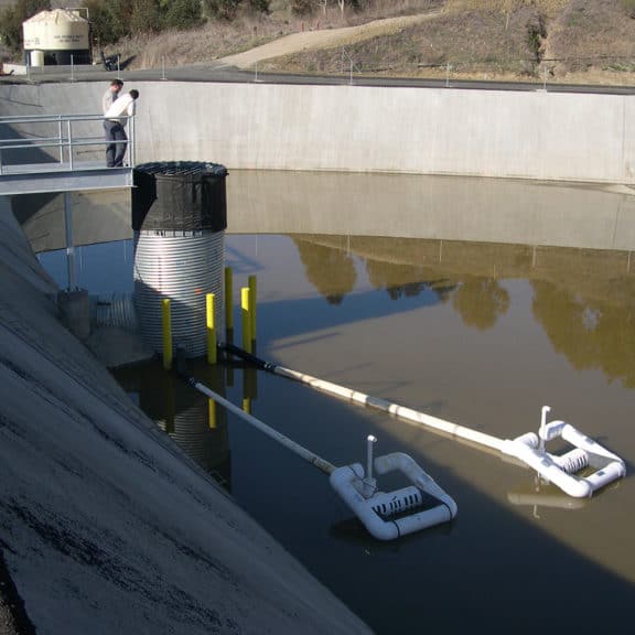 Two skimmers floating in a basin, slowly draining draining it and extracting pollutant-free water