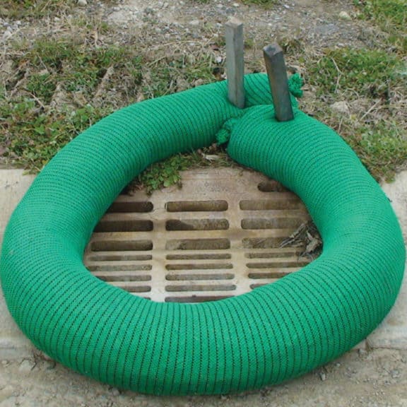 Filter Soxx completely surrounding a stormwater grate/drain near a job site to fully trap sediment & runoff