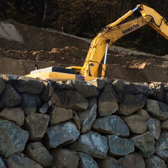 Large excavator building a retaining wall