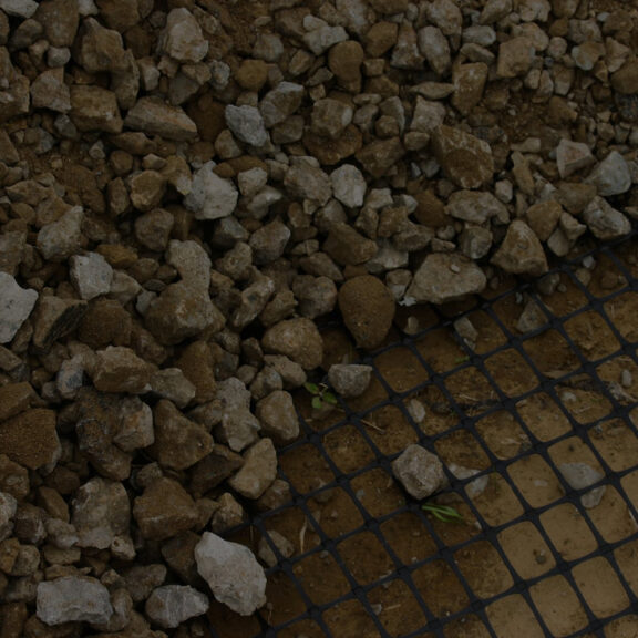 A biaxial geogrid provides support for aggregate, extending the life of pavement