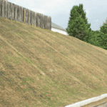 Geosynthetics protect hill from erosion, replacing timber wall.