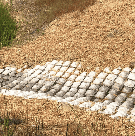 Grout mattress for erosion control near a roadside basin.