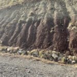 Installing proper drainage channels on a slope to encourage vegetation and prevent erosion.