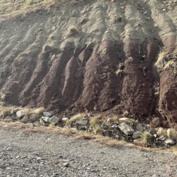 Installing proper drainage channels on a slope to encourage vegetation and prevent erosion.