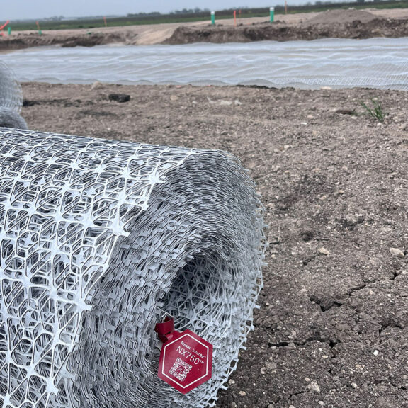 A roll of NX750 InterAx Geogrid at a construction site.