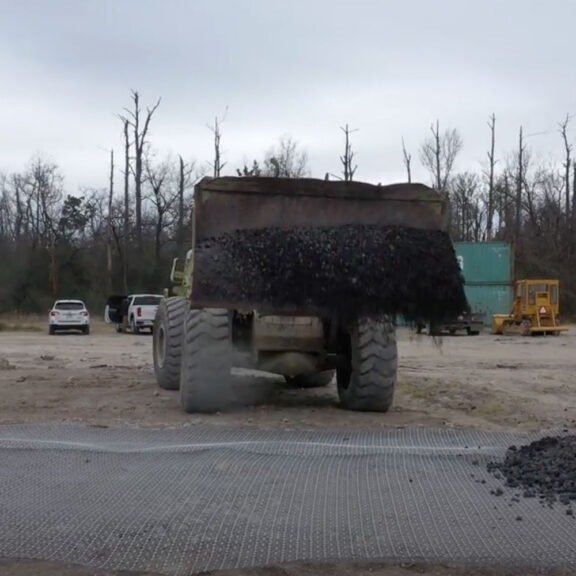 Using large equipment to fill the Tensar NX850 geogrid, an alternative to chemically treating the subgrade for stabilization.