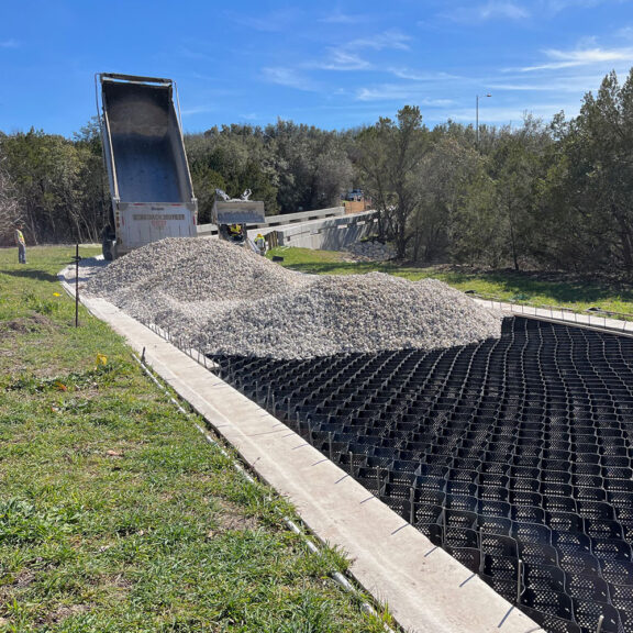 Filling a Presto Geoweb System with aggregate so it is confined and provides increased stability.