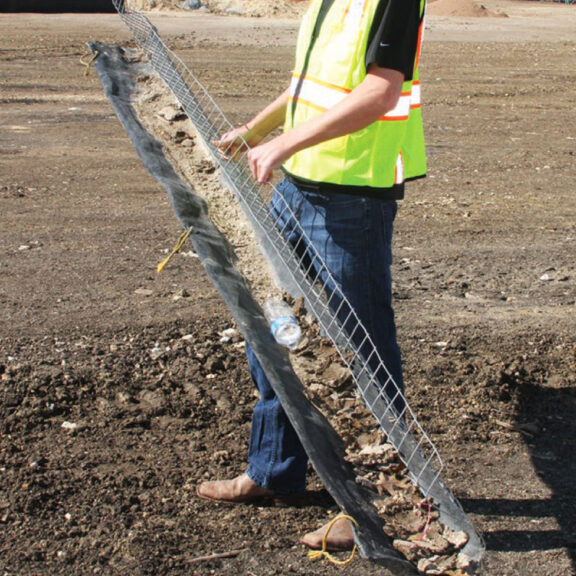 A stormwater professional cleaning and reinserting a curb inlet filter