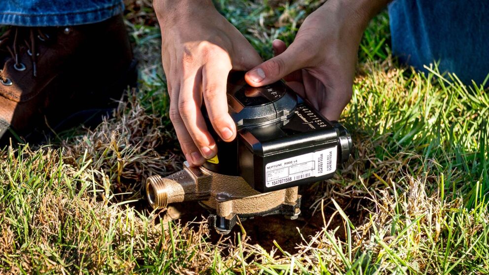 Closeup view of a water meter being installed in the ground.