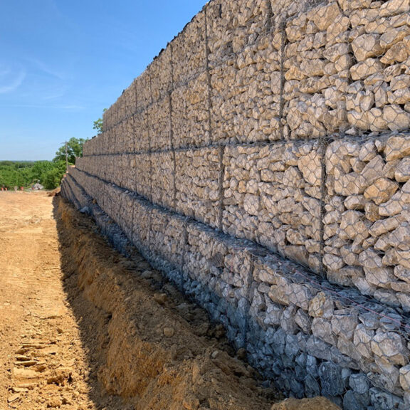 Retaining wall with wire cages and stones